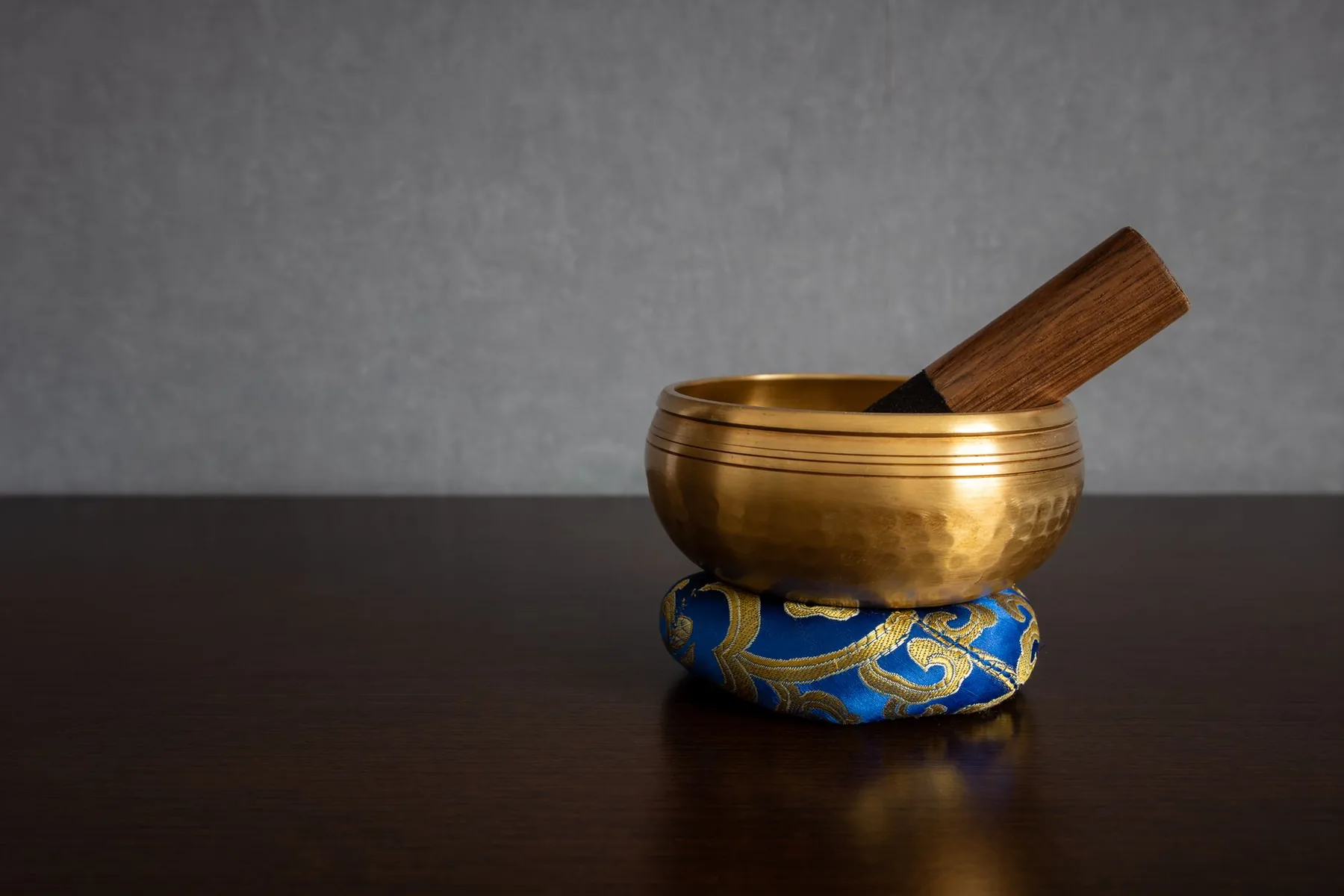 Golden singing bowl with a wooden mallet Golden singing bowl with a wooden mallet