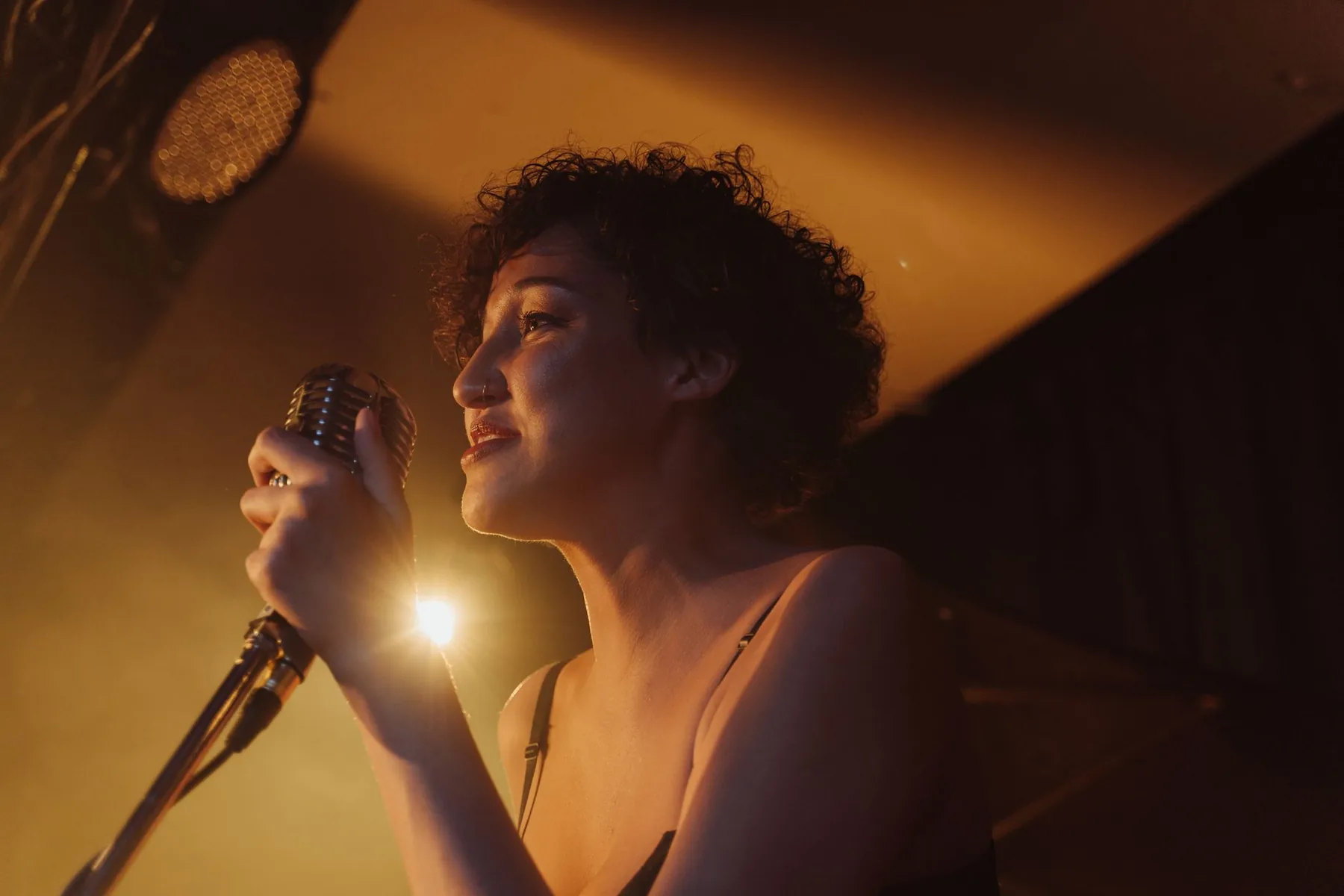 Chanteuse au microphone sous un éclairage doré