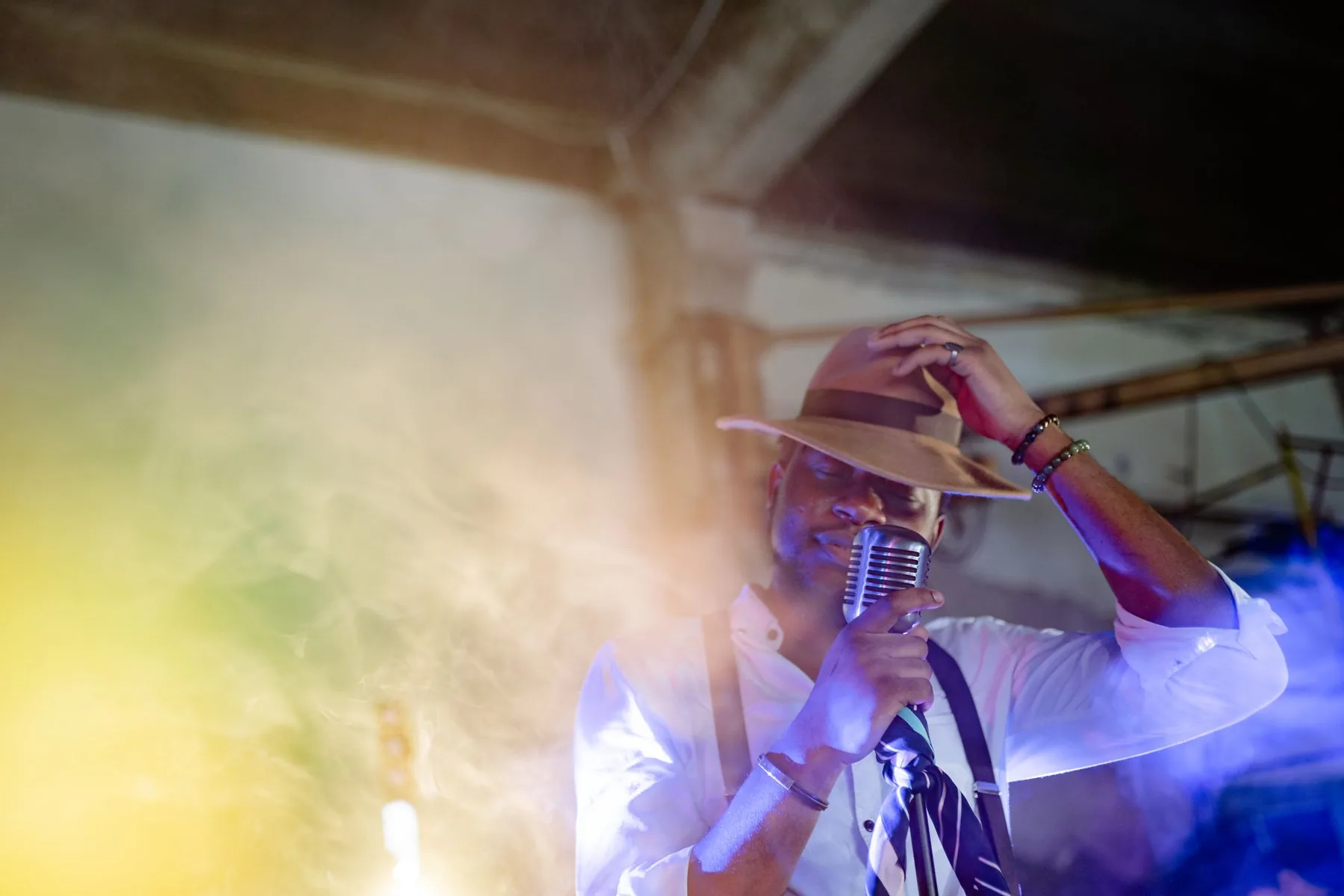 Singer in a hat before a vintage microphone Singer in a hat before a vintage microphone