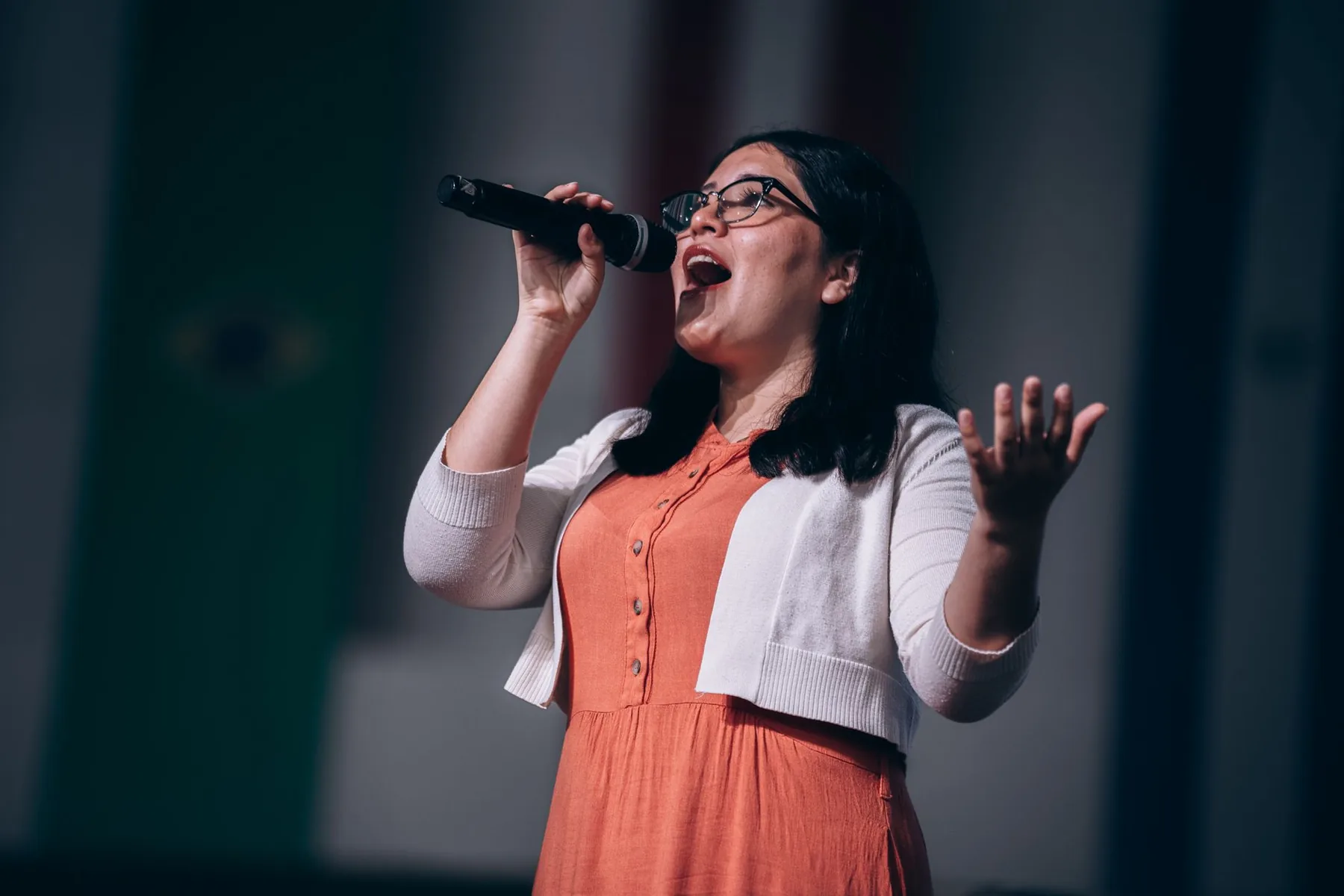 Chanteuse à lunettes interprétant un morceau au microphone