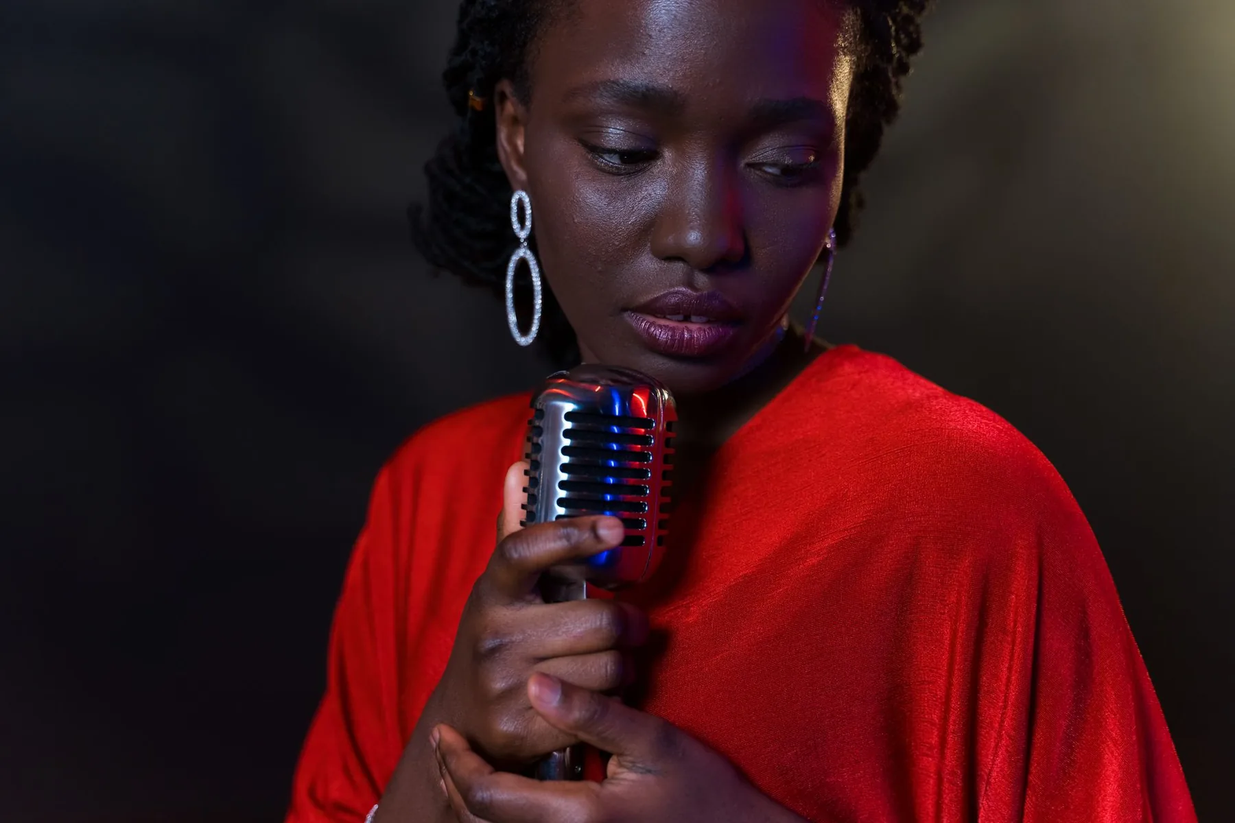 Singer in a red outfit holding a retro microphone Singer in a red outfit holding a retro microphone