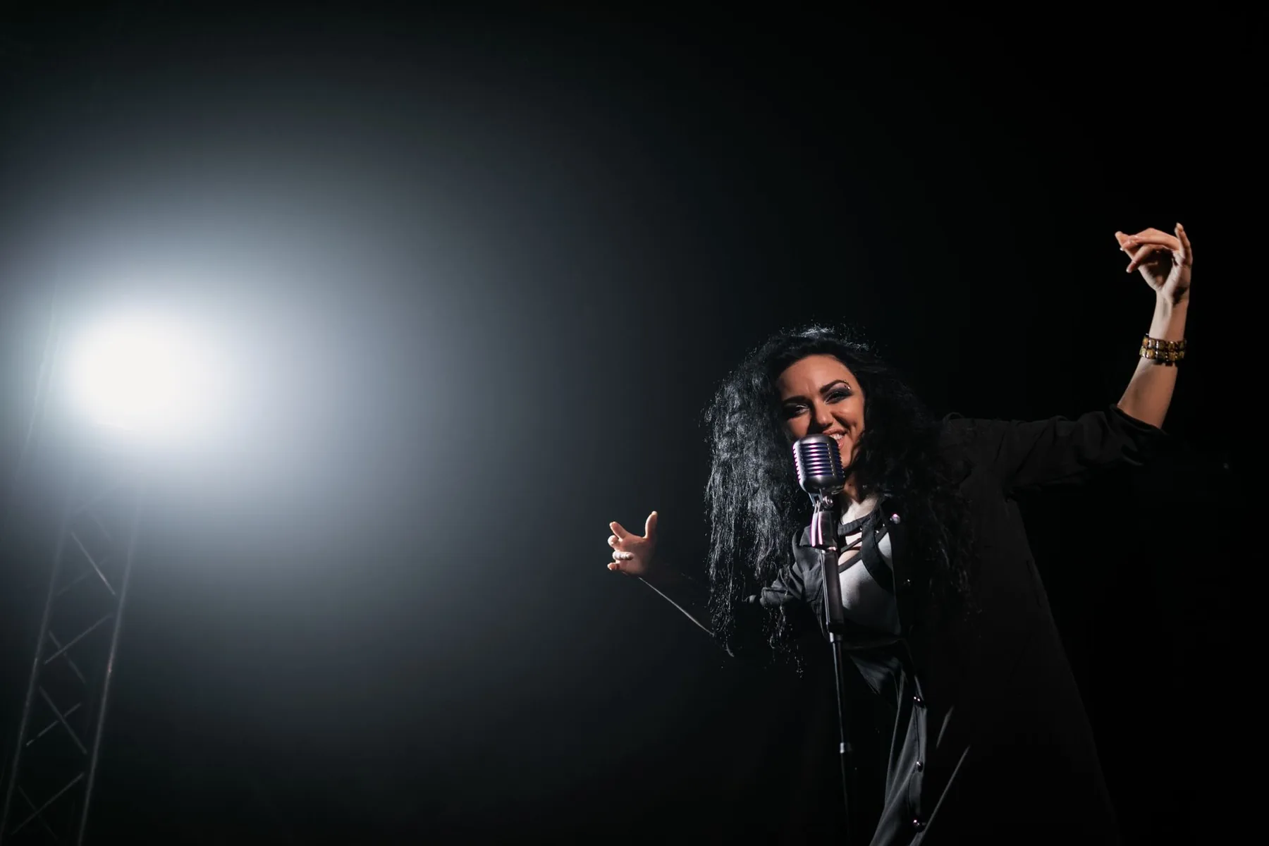 Chanteuse sur scène devant un microphone rétro Chanteuse sur scène devant un microphone rétro