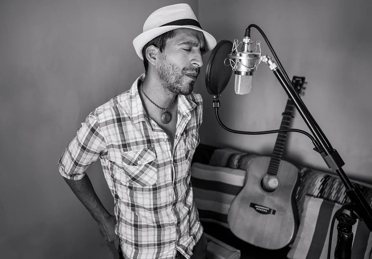 Singer wearing a hat in front of a microphone