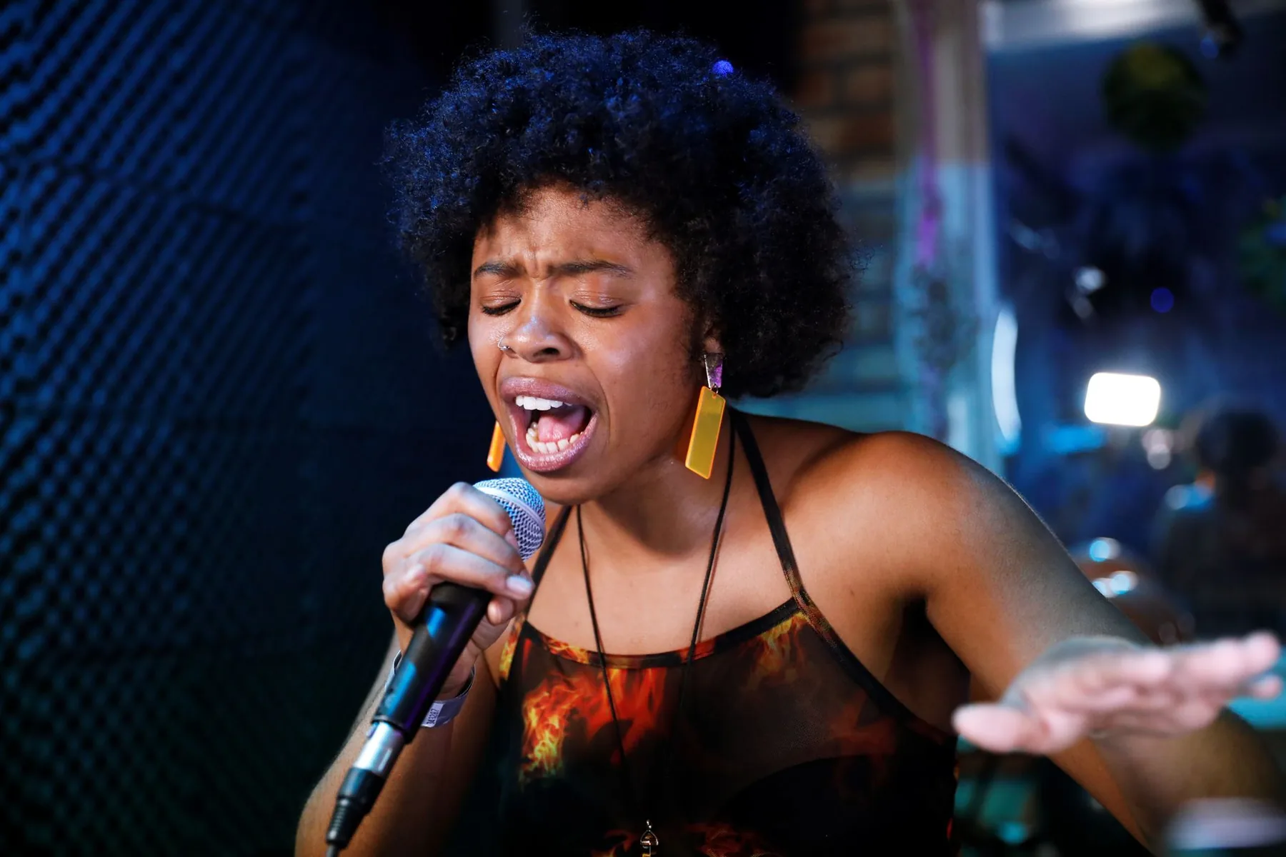 Singer at a microphone with her eyes closed
