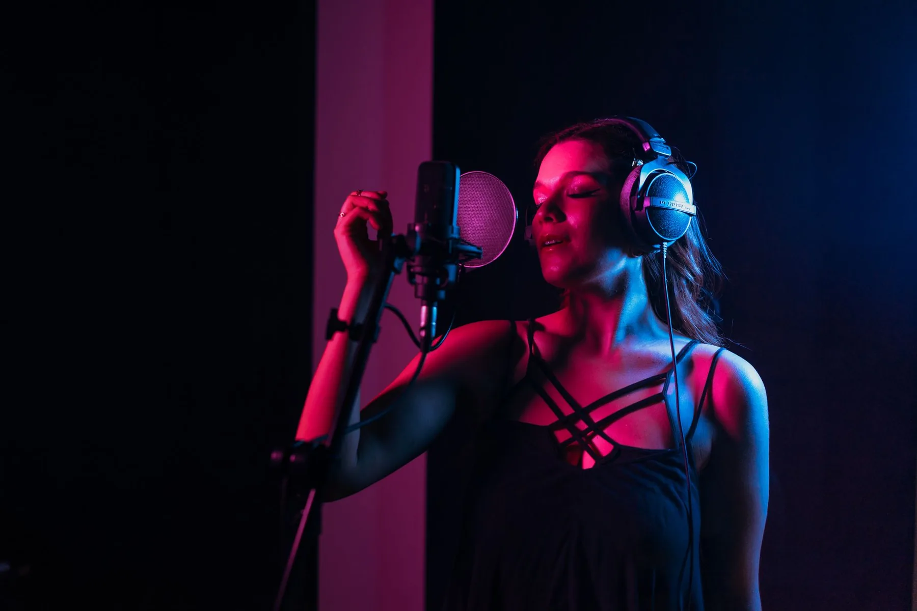 Singer in a studio under pink and blue lighting