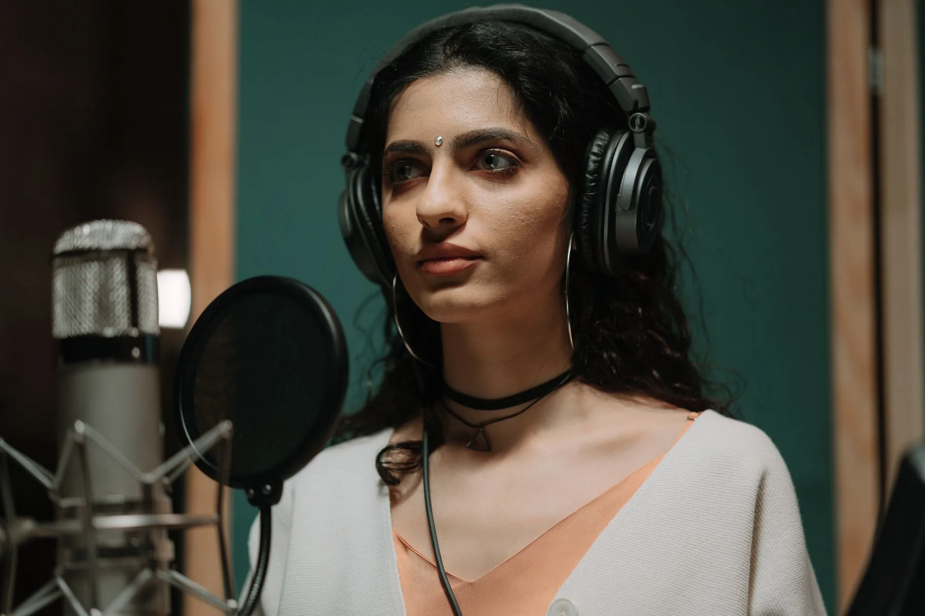 Singer wearing headphones at a studio microphone Singer wearing headphones at a studio microphone