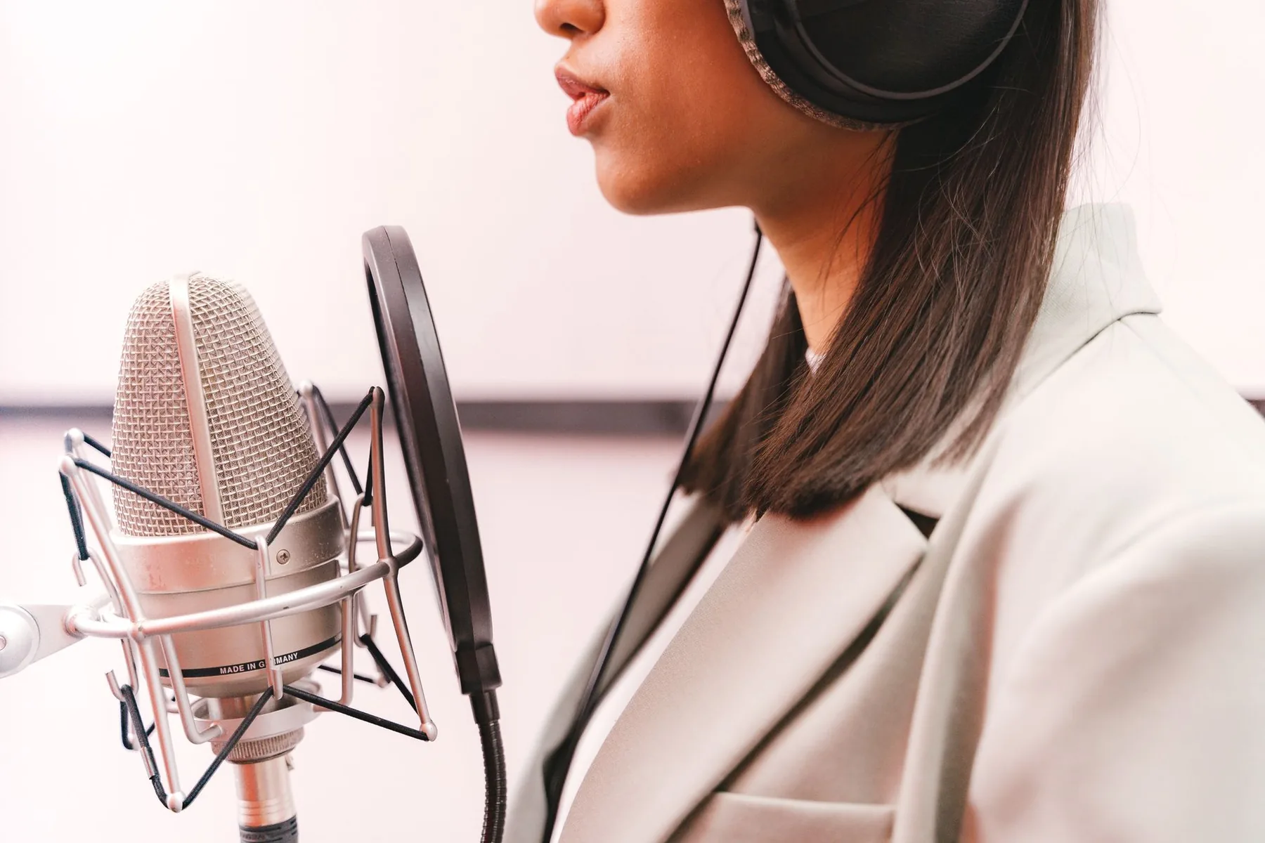 Chanteuse avec casque devant un microphone de studio Chanteuse avec casque devant un microphone de studio