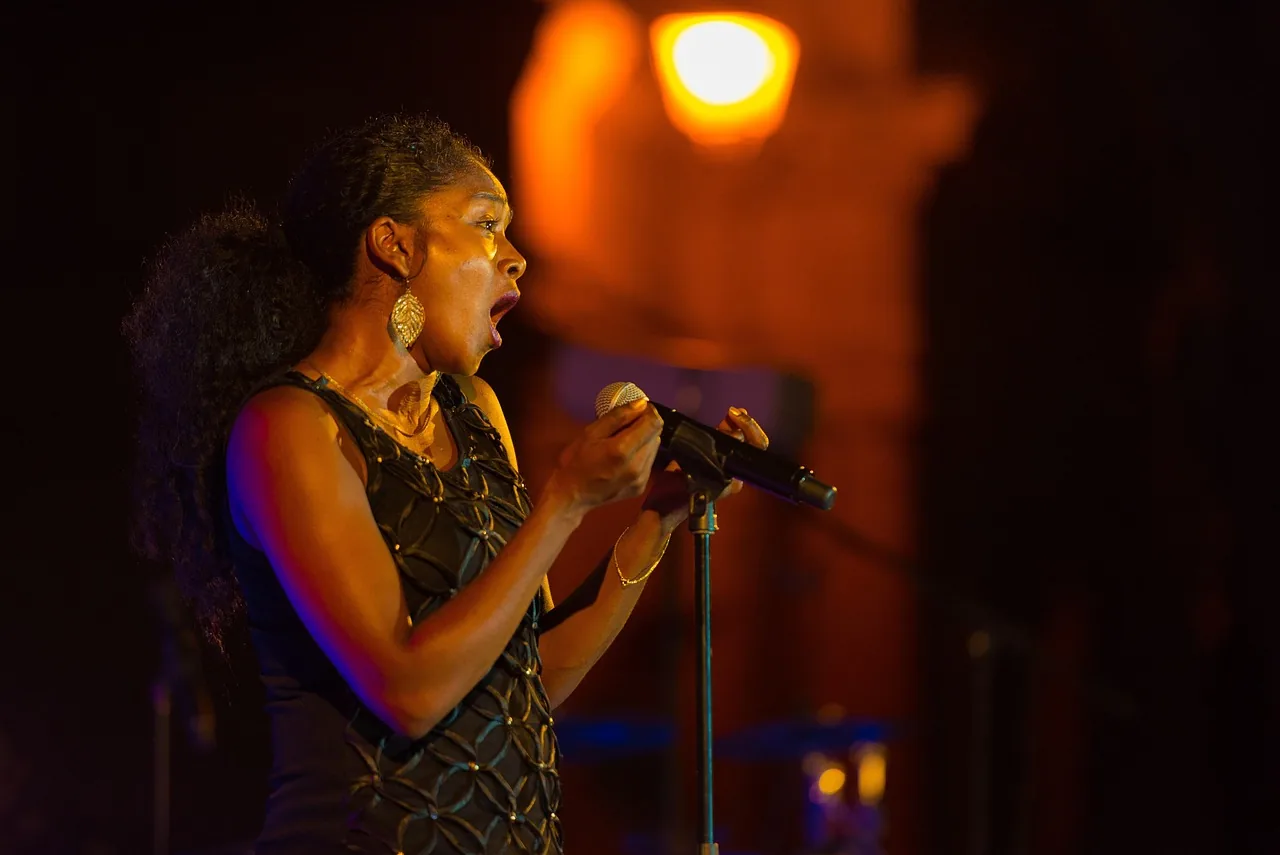 Chanteuse sur scène sous un éclairage orangé
