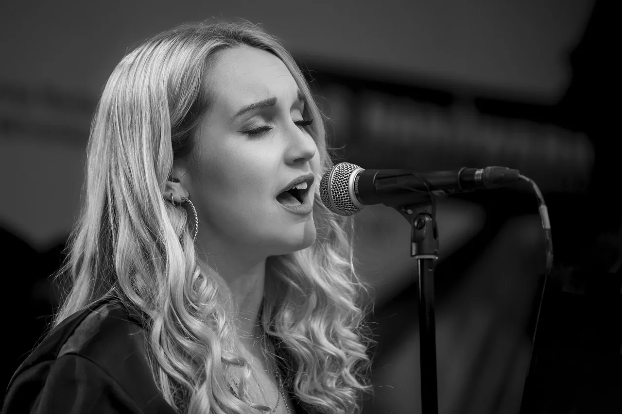 Singer at a microphone in black and white Singer at a microphone in black and white