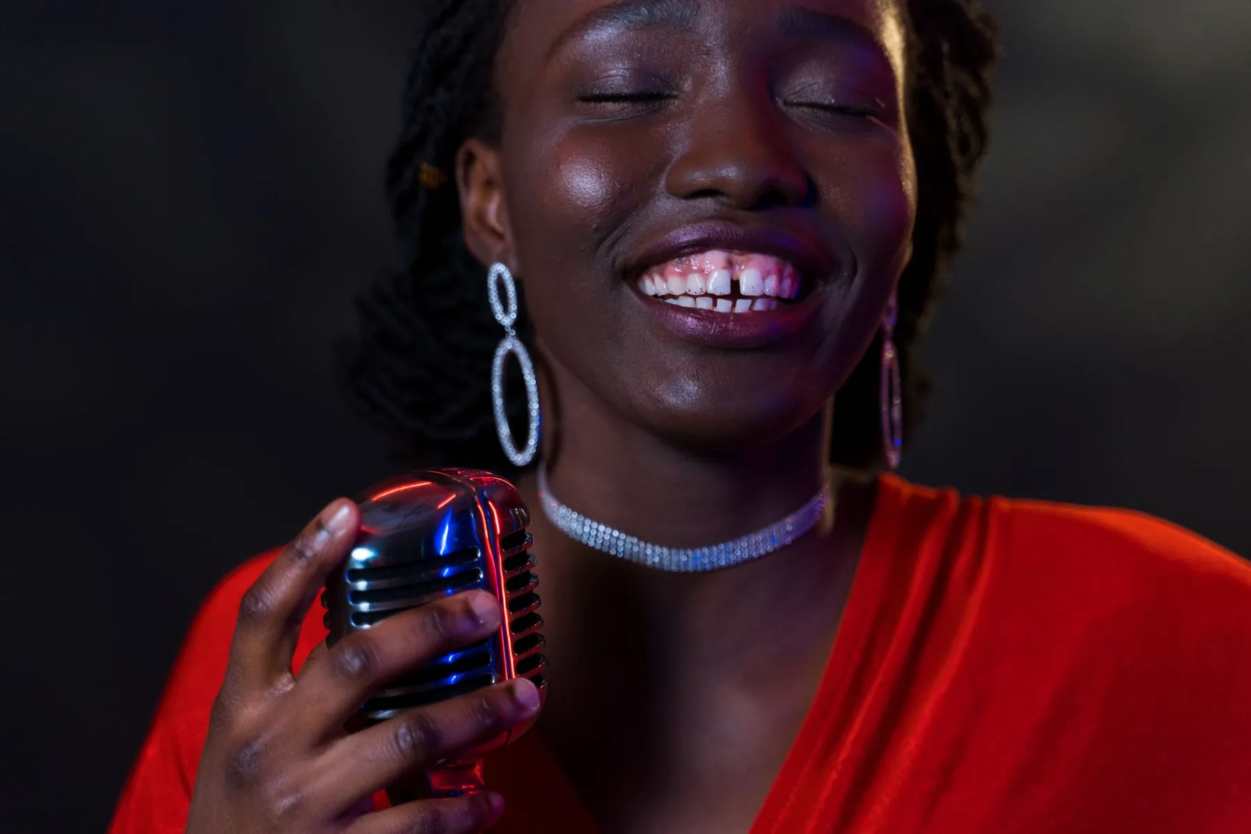 Singer in red holding a retro microphone Singer in red holding a retro microphone