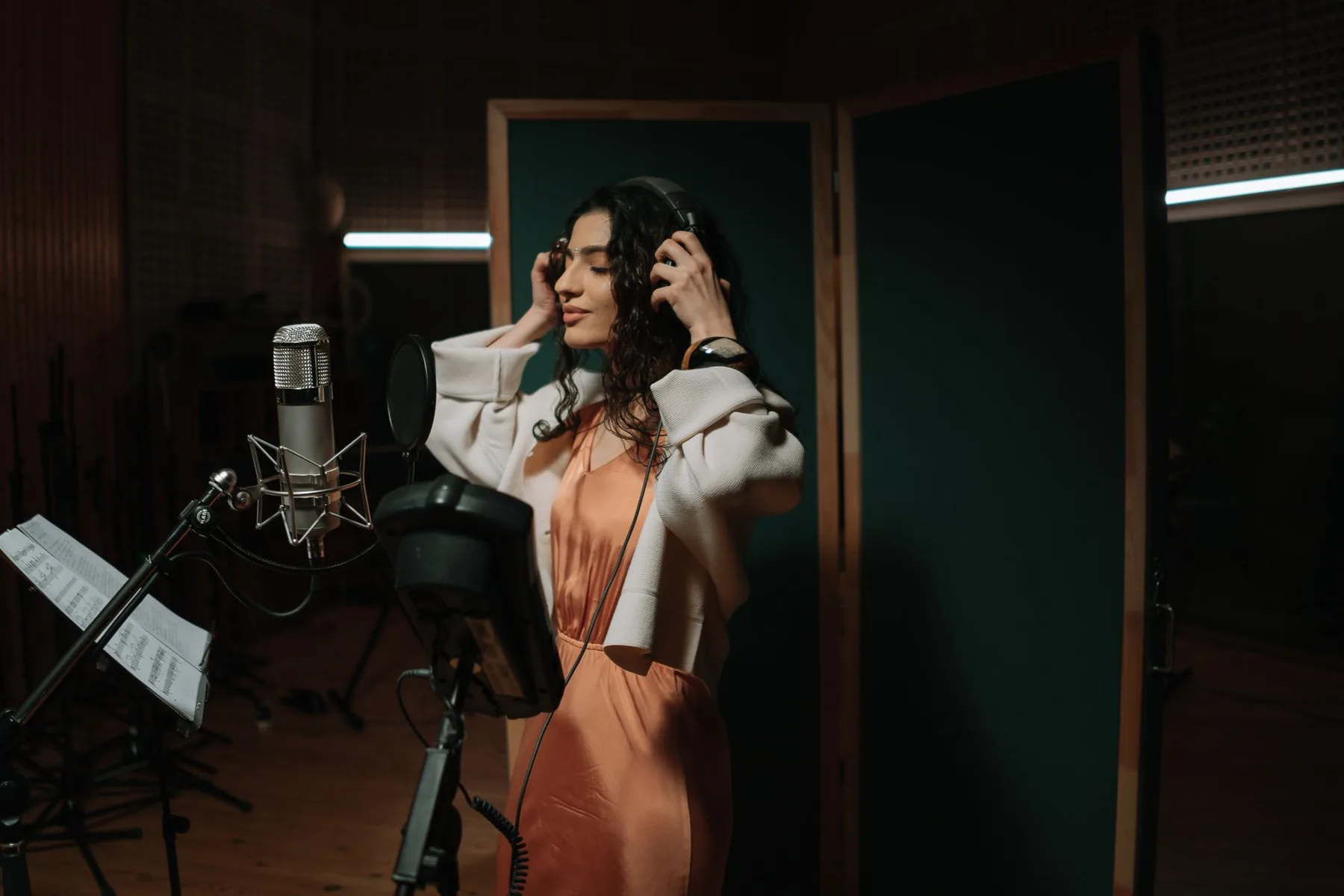 Chanteuse au casque devant une partition en studio Chanteuse au casque devant une partition en studio