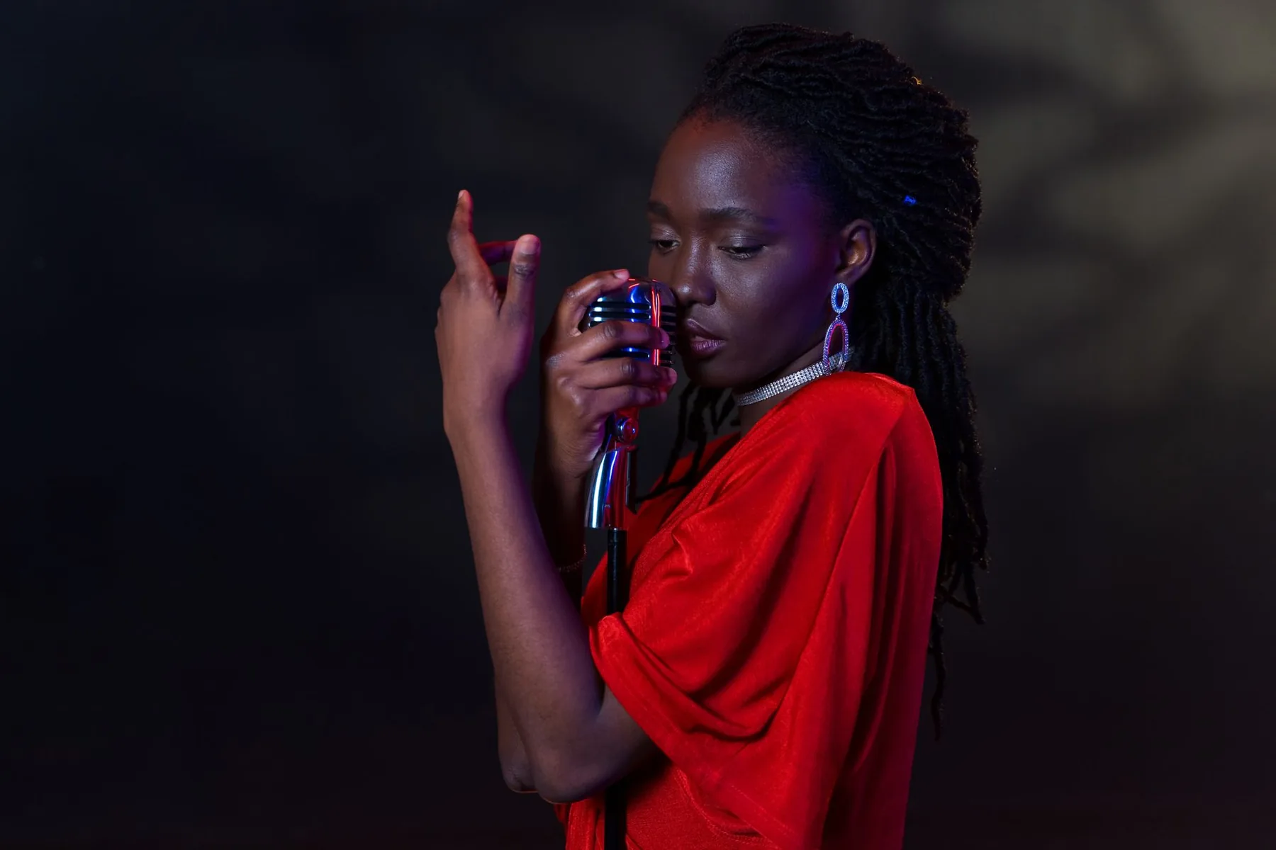 Chanteuse en rouge devant un microphone rétro Chanteuse en rouge devant un microphone rétro