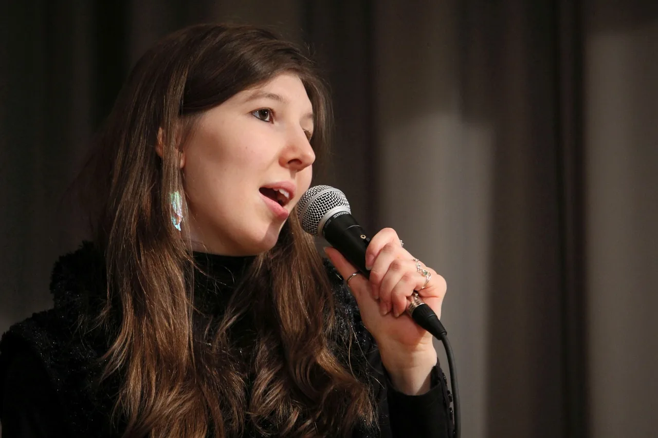Long-haired singer holding a microphone Long-haired singer holding a microphone