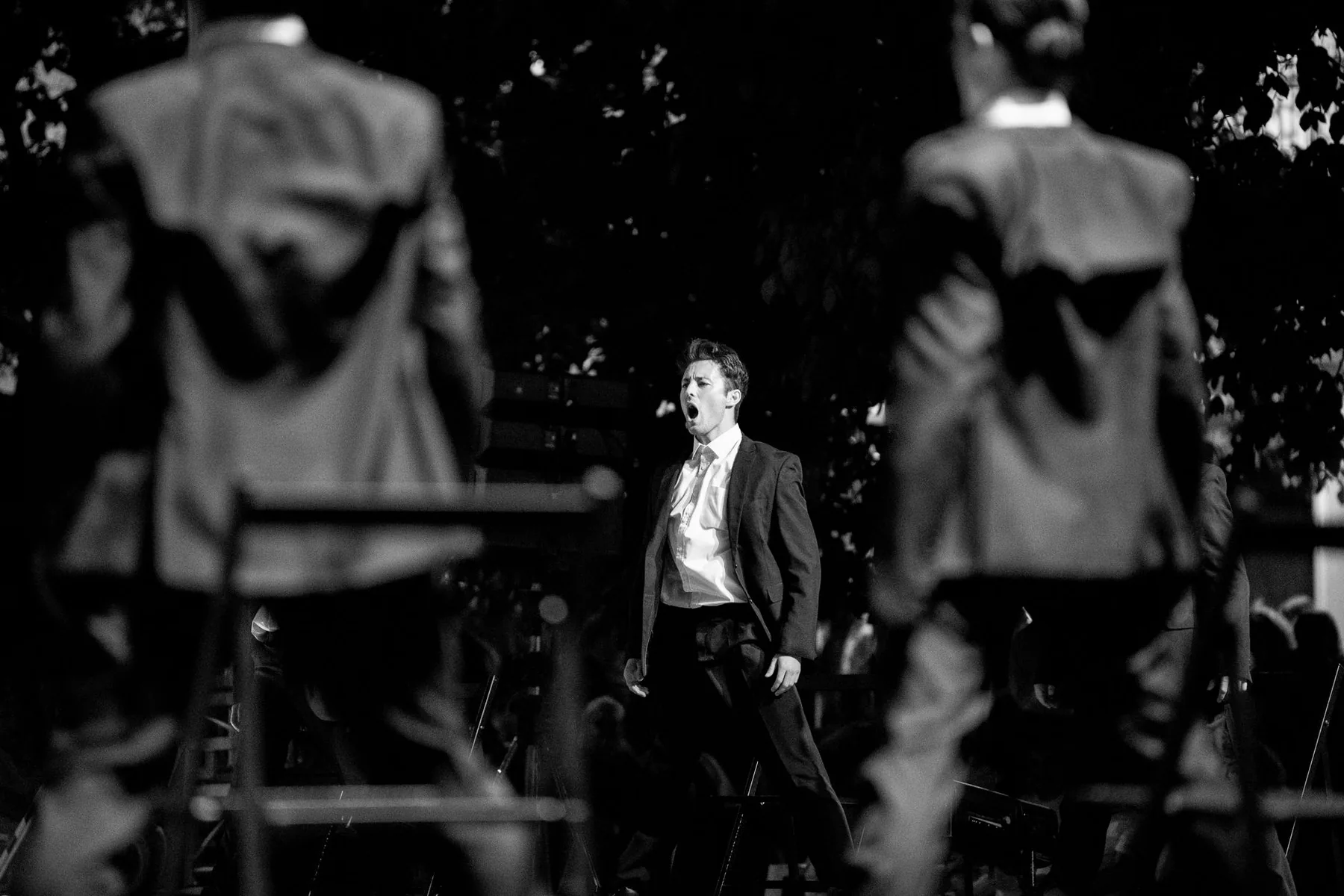 Chanteur en costume devant un ensemble musical Chanteur en costume devant un ensemble musical