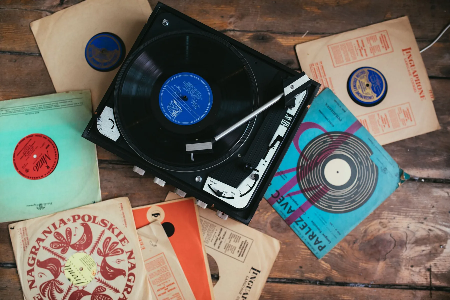 Disque sur platine entourée de pochettes anciennes Disque sur platine entourée de pochettes anciennes