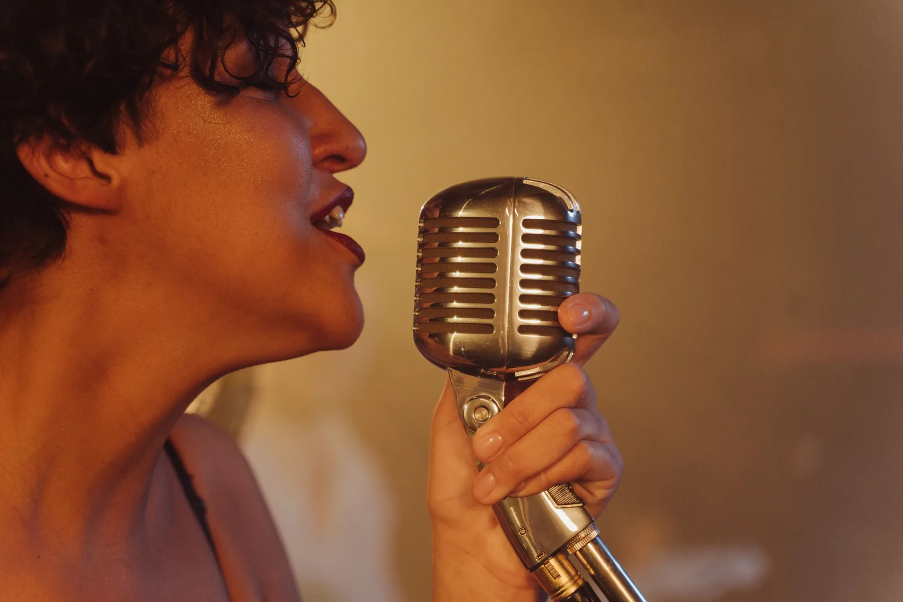Singer at a retro microphone in warm light Singer at a retro microphone in warm light