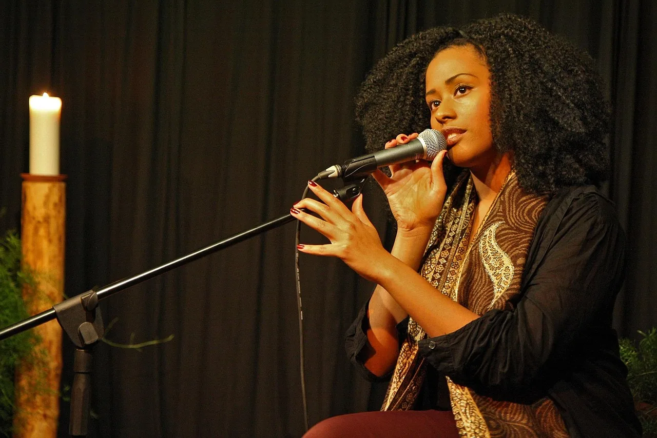 Chanteuse au microphone devant un rideau noir