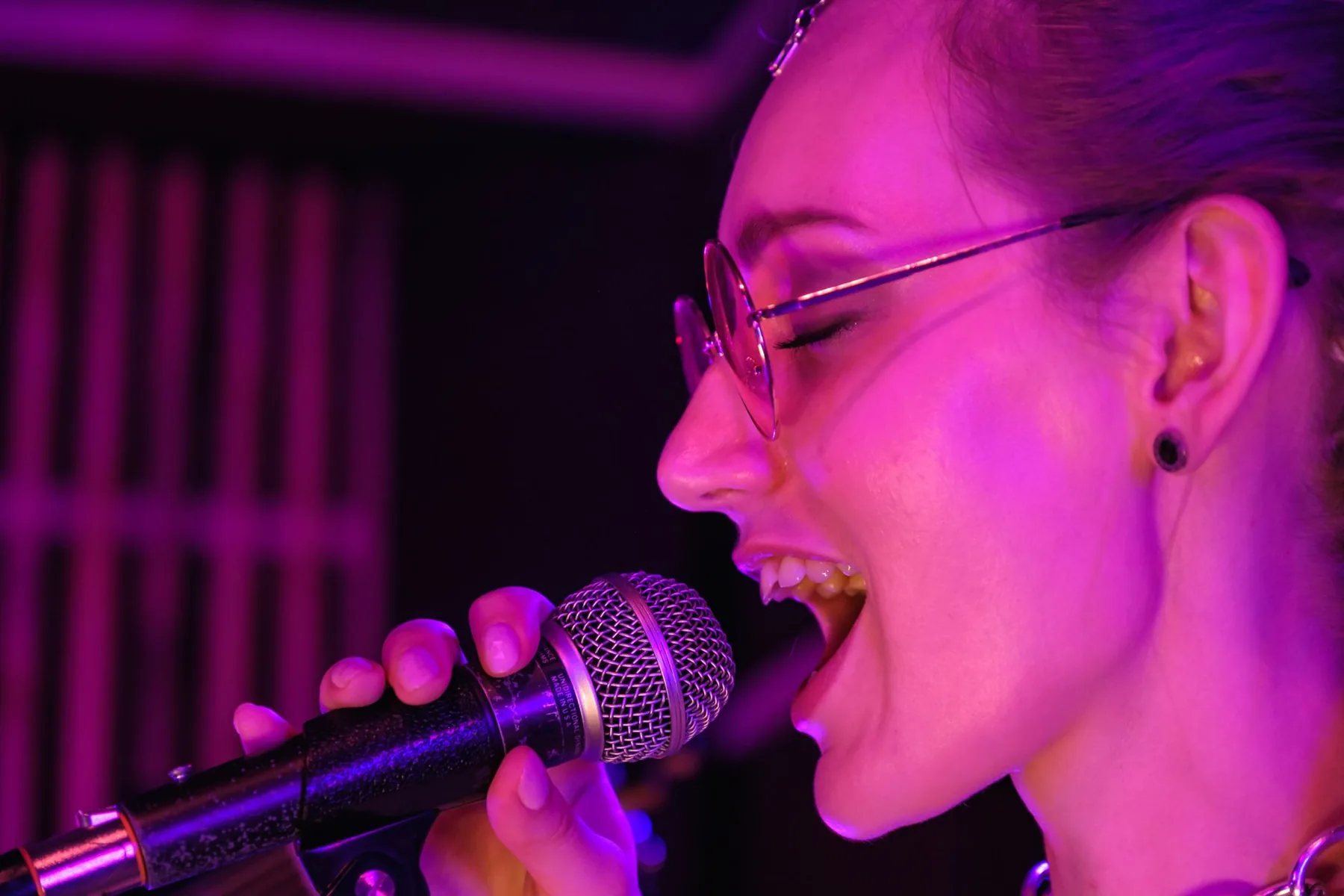 Singer in profile under purple lighting Singer in profile under purple lighting