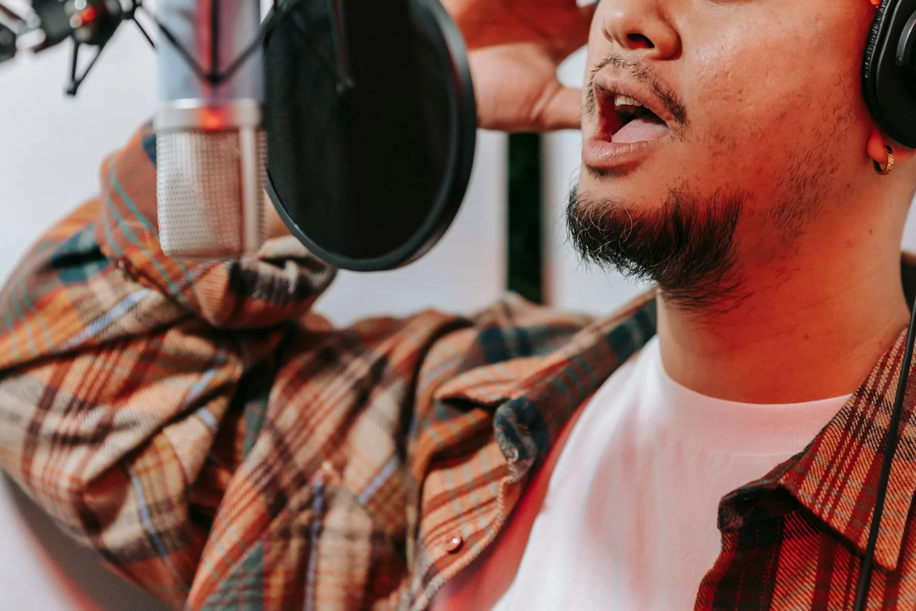 Chanteur au casque devant un microphone de studio Chanteur au casque devant un microphone de studio
