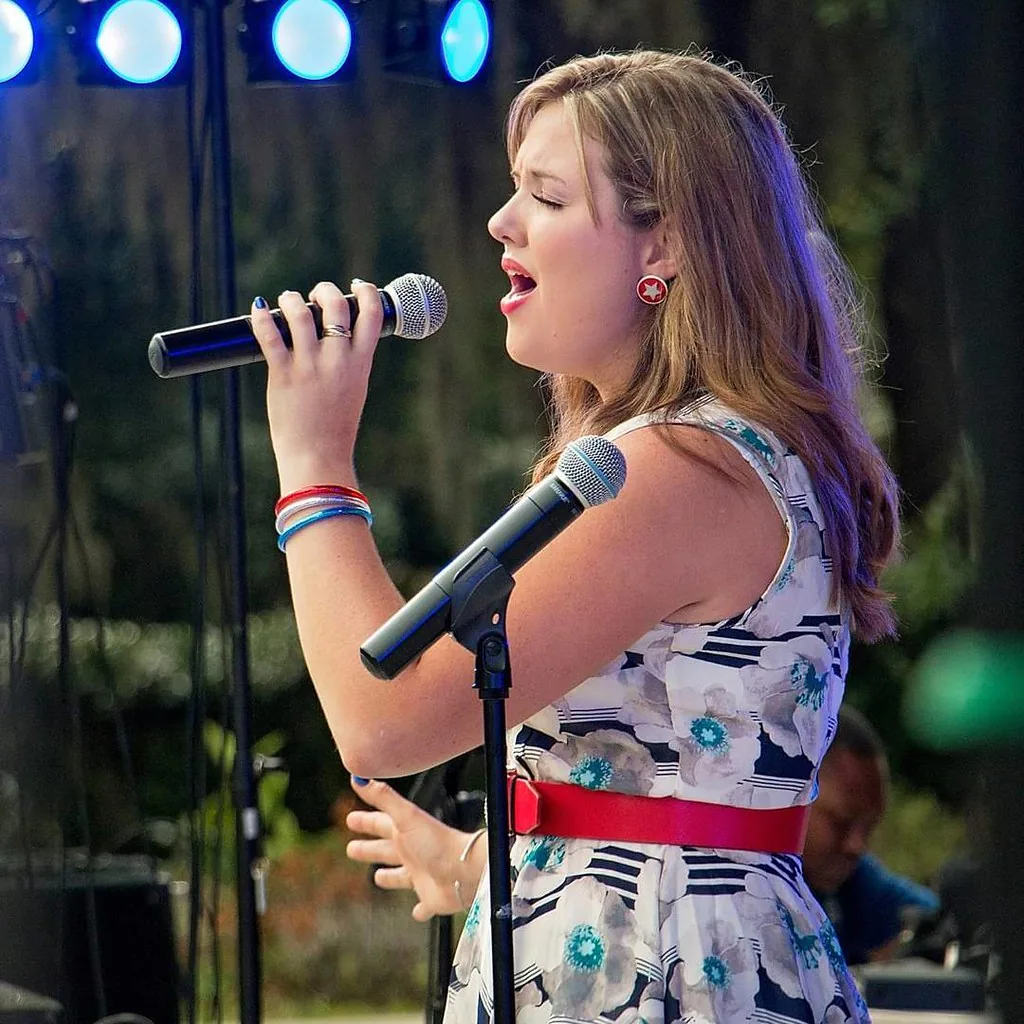Singer onstage holding a microphone Singer onstage holding a microphone