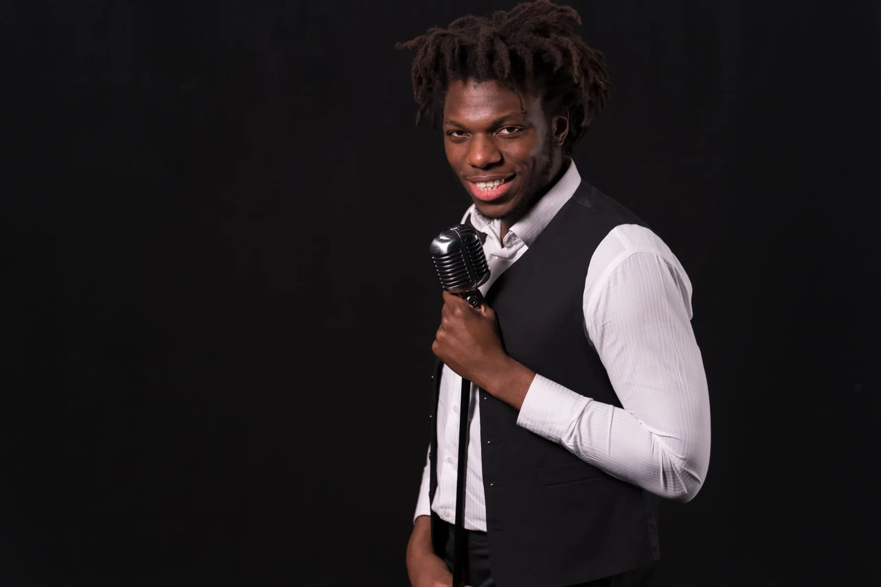 Smiling singer holding a vintage microphone Smiling singer holding a vintage microphone