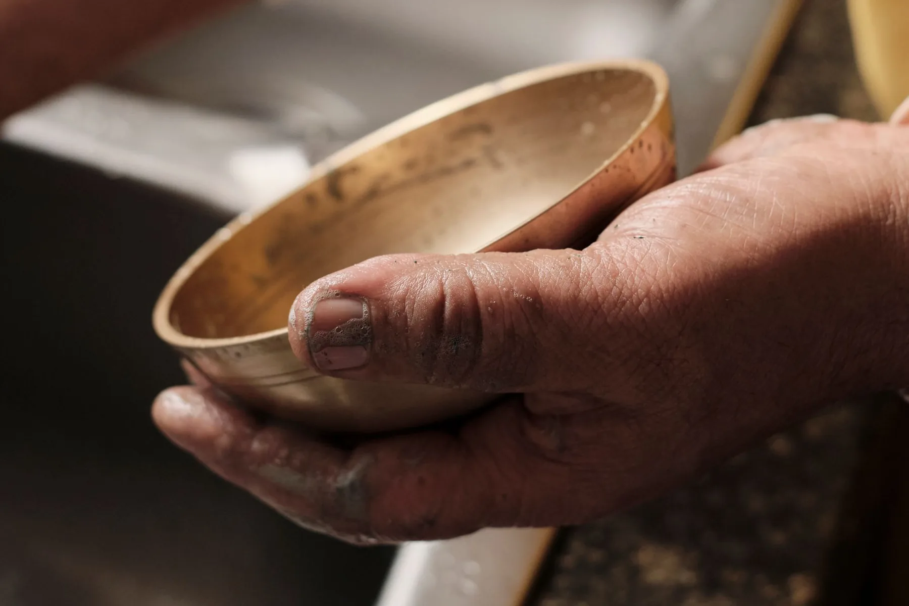 Metal singing bowl held in a hand Metal singing bowl held in a hand