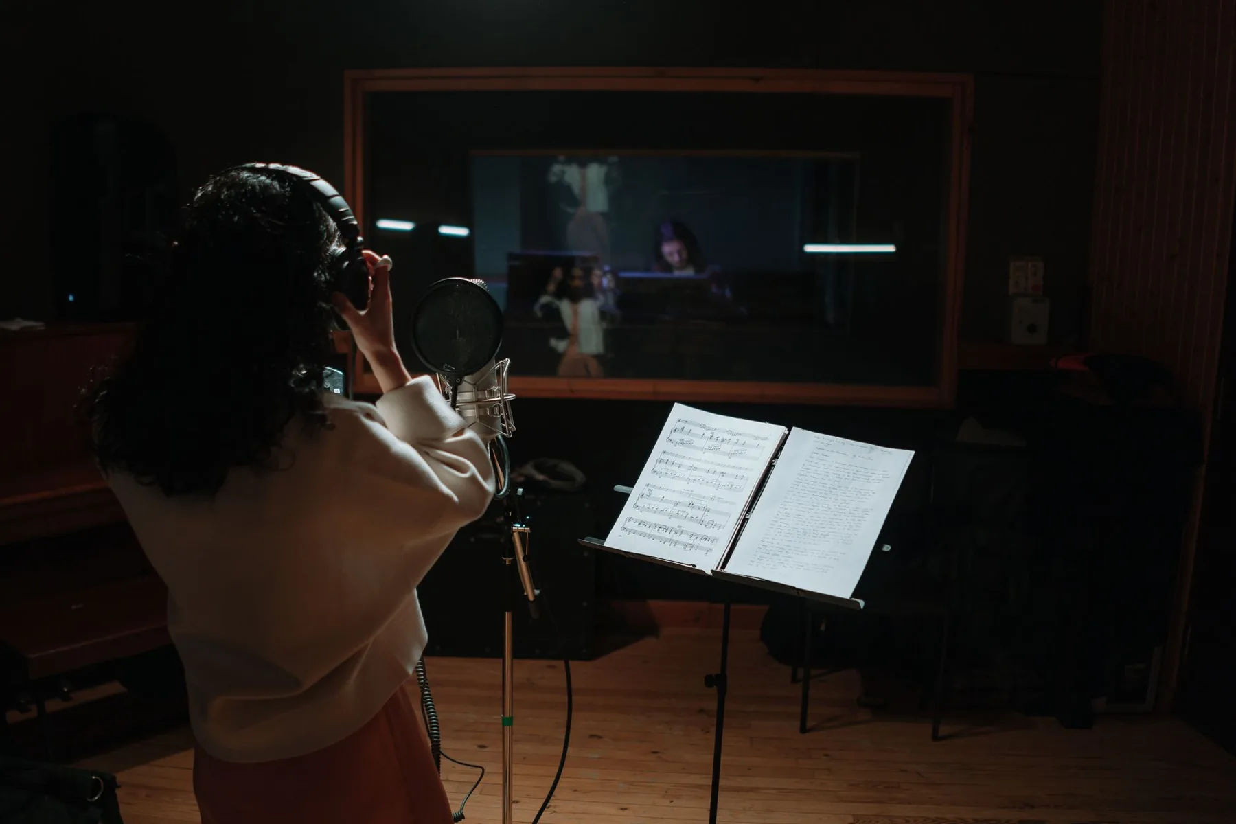 Performer wearing headphones reading a score in the studio Performer wearing headphones reading a score in the studio