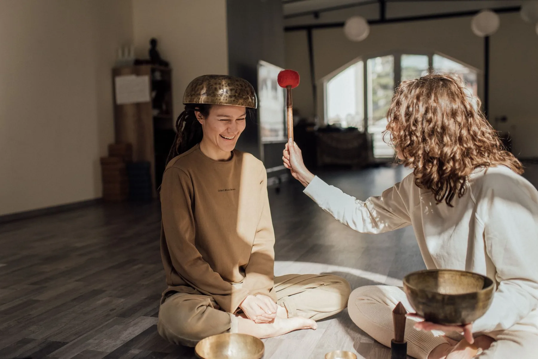 Two people with Tibetan singing bowls and a mallet Two people with Tibetan singing bowls and a mallet
