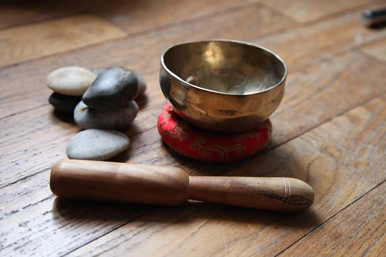 Tibetan singing bowl on a red cushion with a mallet Tibetan singing bowl on a red cushion with a mallet