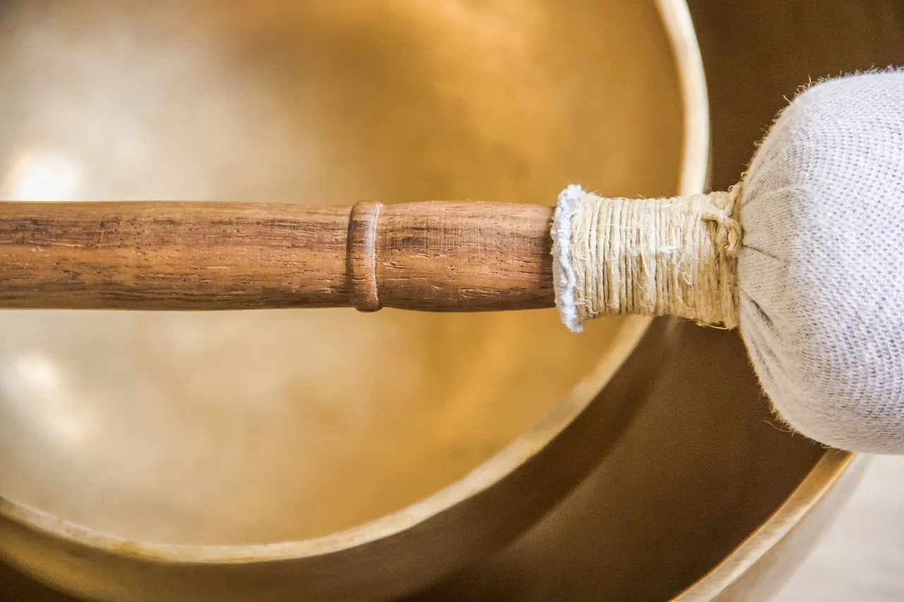 Wooden mallet in front of Tibetan singing bowls Wooden mallet in front of Tibetan singing bowls