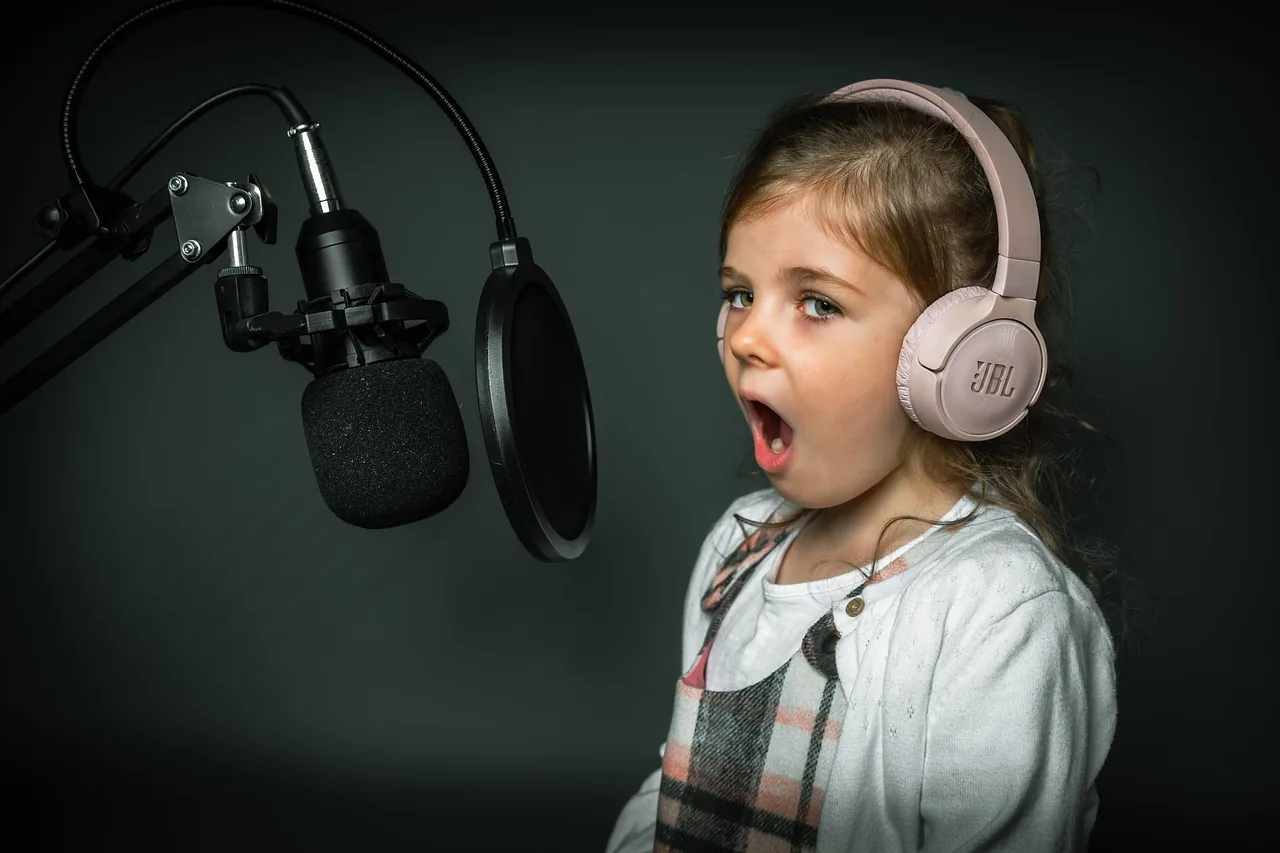 Young woman singing into a microphone in a studio