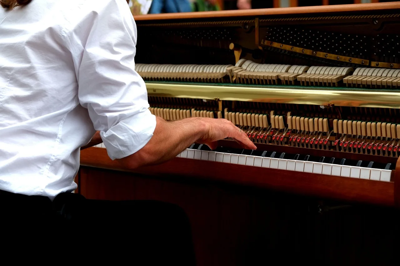 Pianist at the keyboard with the piano action exposed