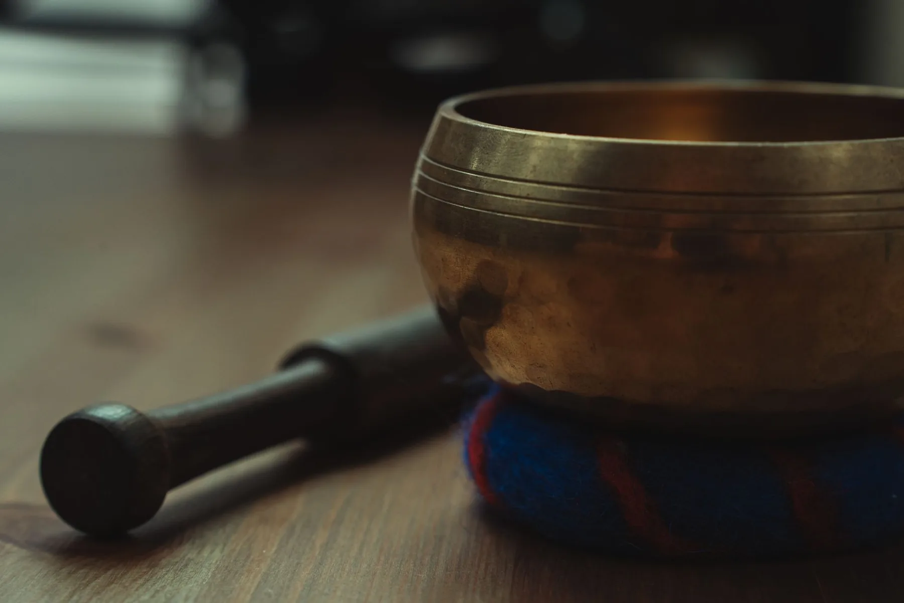 Tibetan singing bowl on a cushion with a wooden mallet Tibetan singing bowl on a cushion with a wooden mallet
