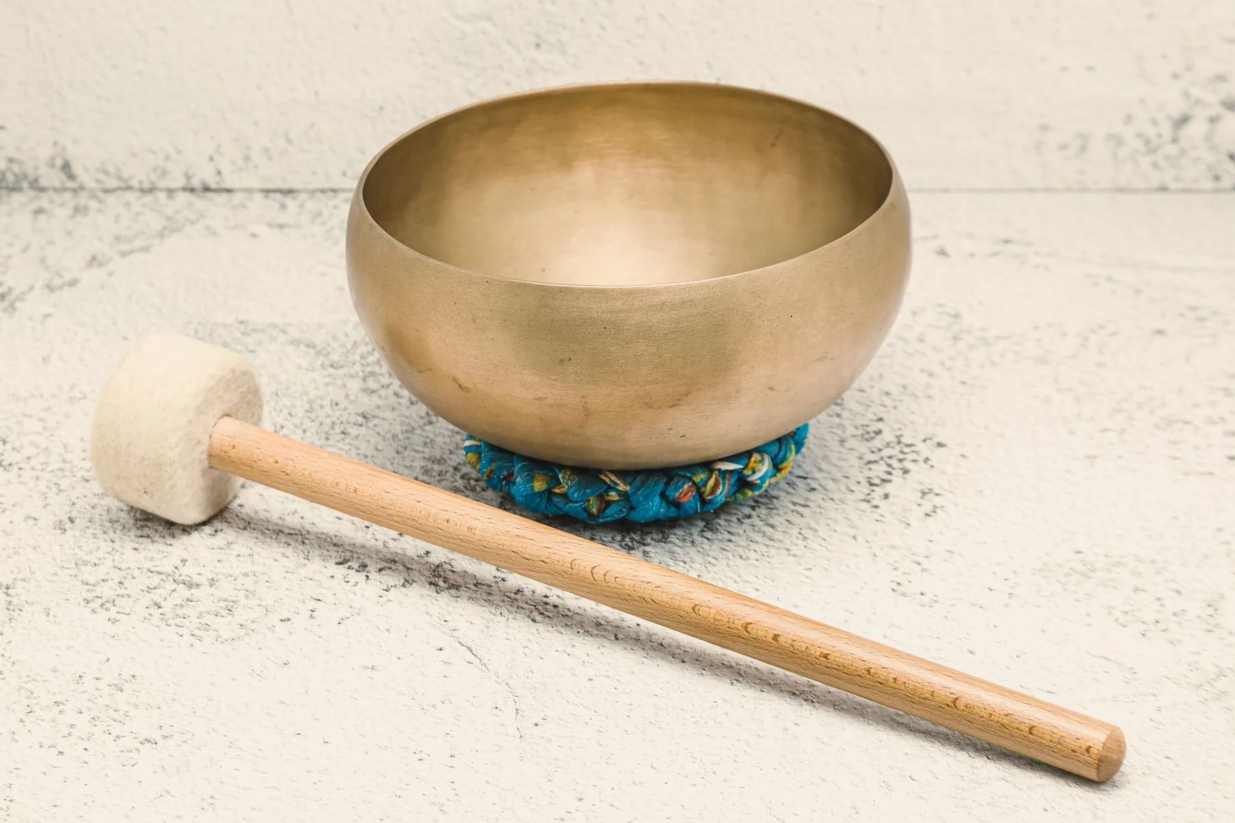 Tibetan singing bowl on a cushion with a wooden mallet Tibetan singing bowl on a cushion with a wooden mallet
